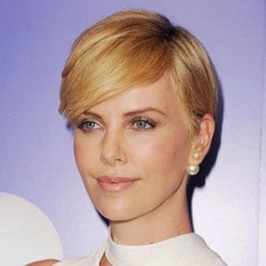A close up of charlize theron with short hair
